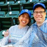 A couple smiling and wearing a poncho at the Comerica Park event